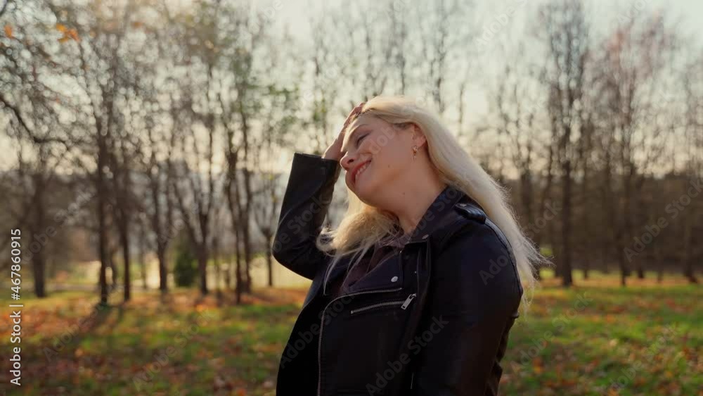 Portrait female person looking at camera in autumn park. Adult 30s woman smile laugh and breath in outdoors in sunshine light Portrait female person looking at camera in autumn park. Adult 30s woman smile laugh and breath in outdoors in sunshine light