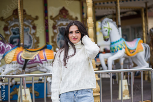 Happy and attractive caucasian brunette girl posing in an amusement park.