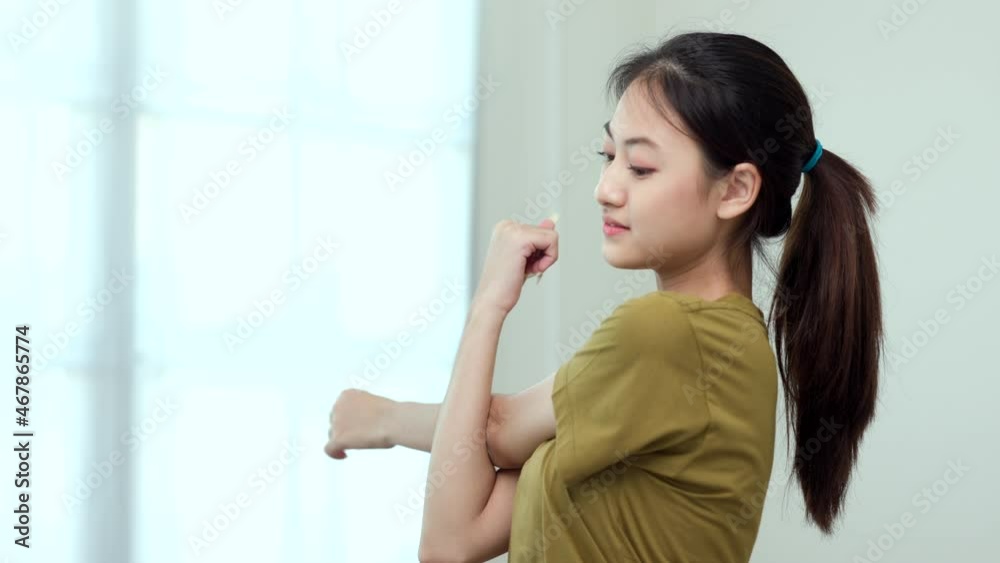 Attractive asian young fitness woman stretching arms warming up before workout at home. Beautiful smiling Female wearing sportswear exercise training yoga in living room. Attractive asian young fitness woman stretching arms warming up before workout at home. Beautiful smiling Female wearing sportswear exercise training yoga in living room.