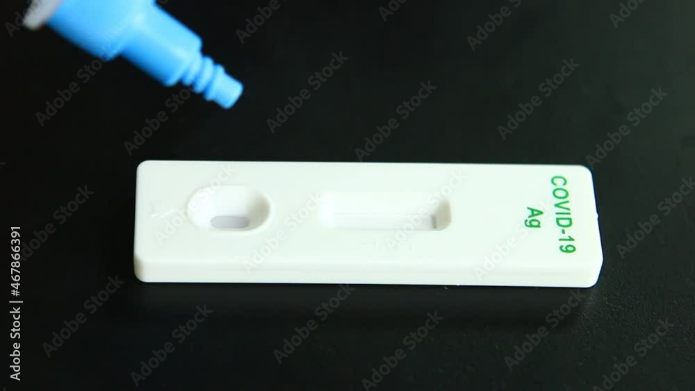 Man dropping secretions with solution on Antigen Test Kit, in studio Chiangmai Thailand. Man dropping secretions with solution on Antigen Test Kit, in studio Chiangmai Thailand.