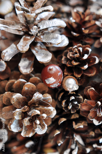 Brown Christmas background with cones and acorns, decorated with pearls