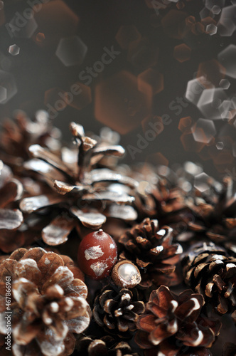 Vertical brown Christmas background with shiny cones and acorns   blurred effect