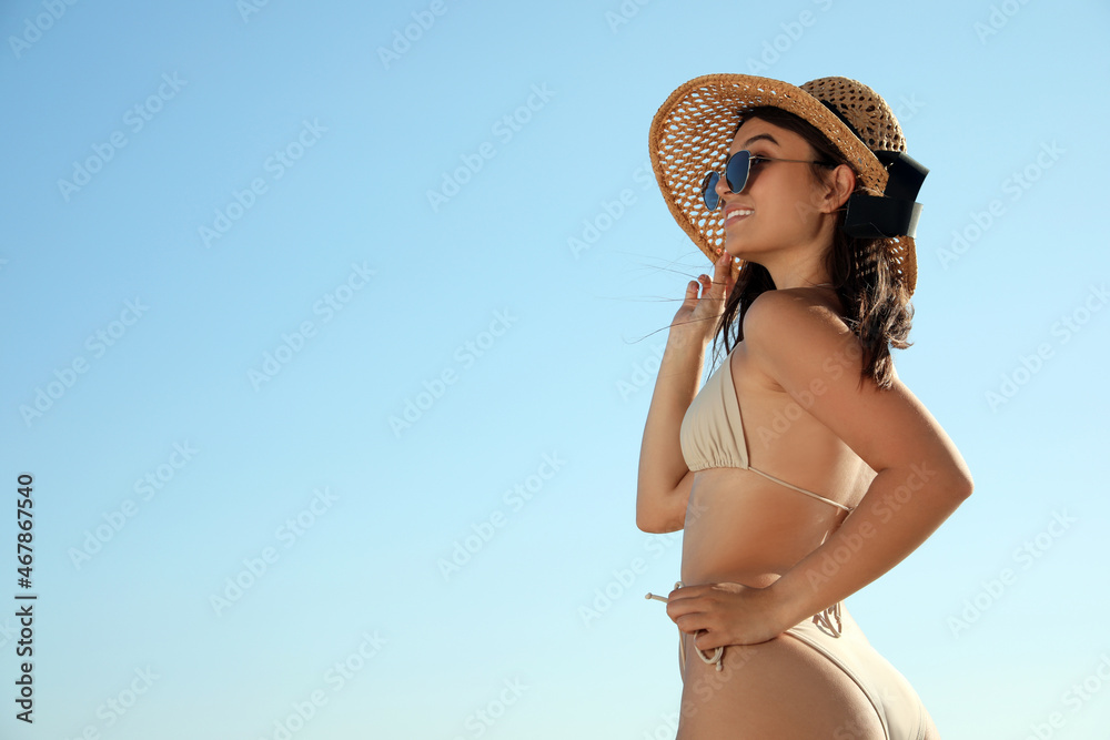 Beautiful young woman with attractive body against blue sky. Space for text