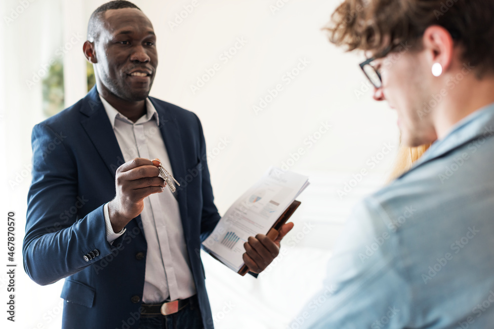 Real estate agent handing the house key to clients Real estate agent handing the house key to clients