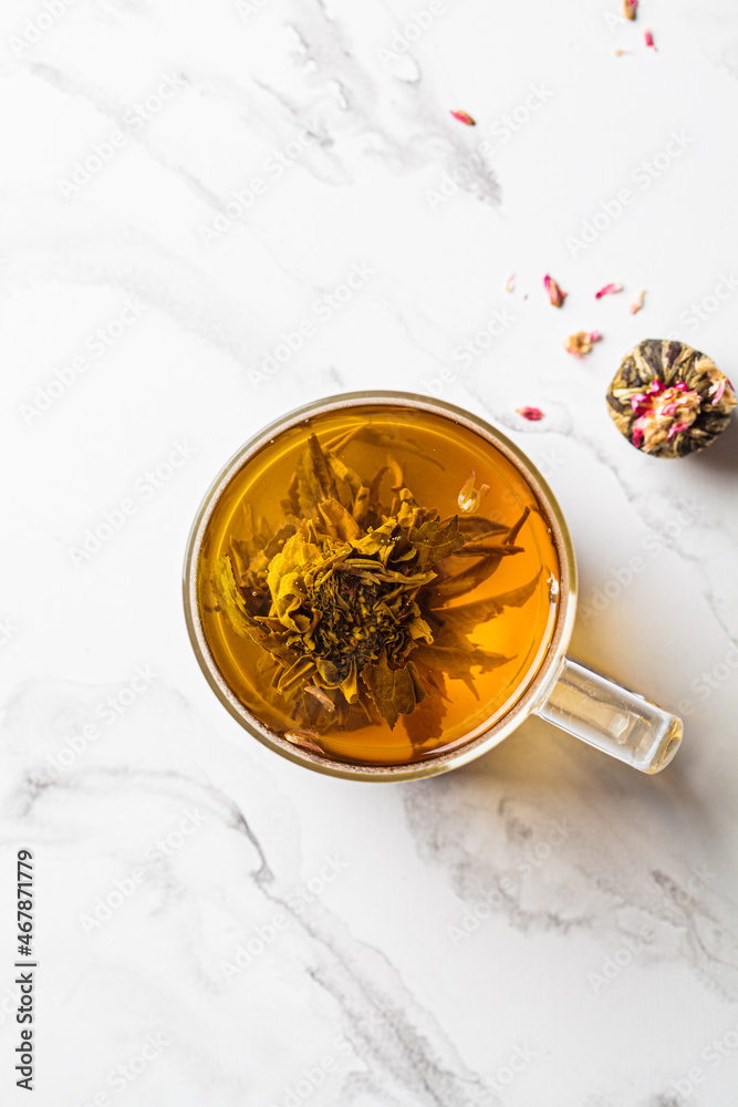 Green tea with flower ball in glass cup, white background. Green tea with flower ball in glass cup, white background.