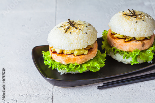 Rice burger with salmon cutlet, avocado and soy sauce, photo