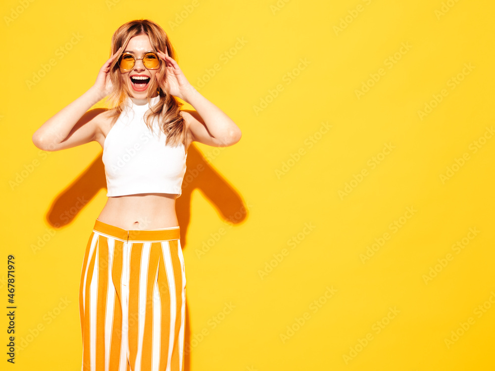 Young beautiful smiling female in trendy summer clothes. Sexy carefree woman posing near blue yellow in studio. Positive model having fun. Cheerful and happy. In sunglasses. Screaming and shouting Young beautiful smiling female in trendy summer clothes. Sexy carefree woman posing near blue yellow in studio. Positive model having fun. Cheerful and happy. In sunglasses. Screaming and shouting