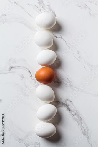 Pattern of white raw chicken eggs on white marble background.
