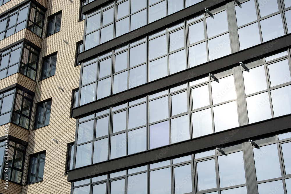 Facade of a new modern building with glass balconies in the concept of a modern city. Bottom view Facade of a new modern building with glass balconies in the concept of a modern city. Bottom view