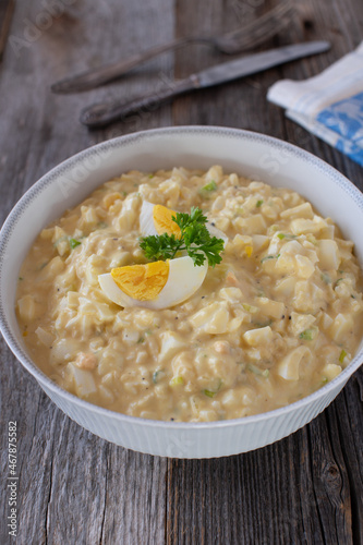 Bow with homemade egg salad on wooden background