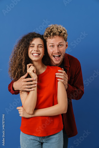 Young white couple hugging while laughing at camera
