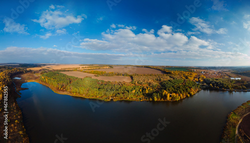 Aerial wide view of lake at sunrise in autumn. Meadows, orange grass. Colorful landscape of river sunset. Horodok Ukraine Fishermen by the river are fishing. Leisure and hobbies. A park old mill