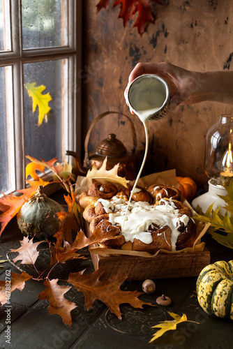 Pumpkin cinnamon rolls with buttery icingn with autumn decoration photo