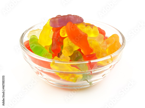 Colorful gummy candies in glass bowl isolated on white background