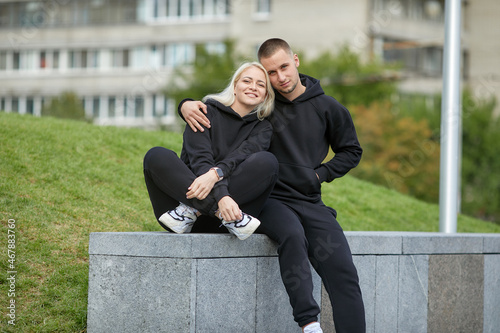 young couple in tracksuits walking around the city