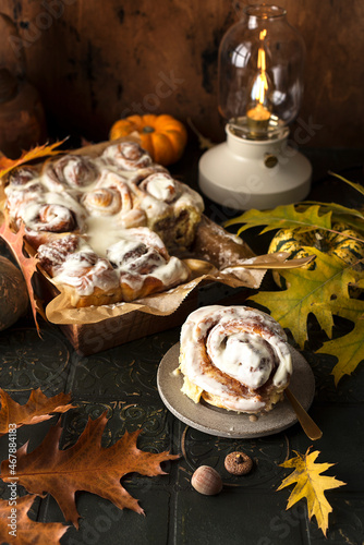 Pumpkin cinnamon rolls with buttery icingn with autumn decoration photo