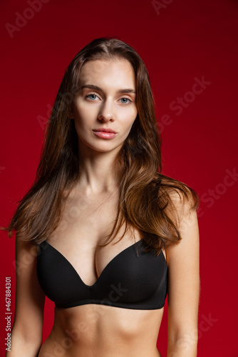 Close-up portrait of young beautiful girl without makeup isolated over red studio background. Natural beauty concept.