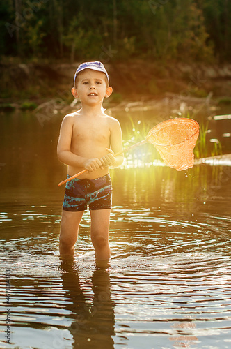 Boy with a butterfly net and a flower going down the river