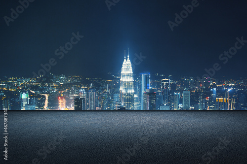 Concrete rooftop with night city view and mock up place for your advertisement. Beautiful backdrop. Downtown and urban concept.