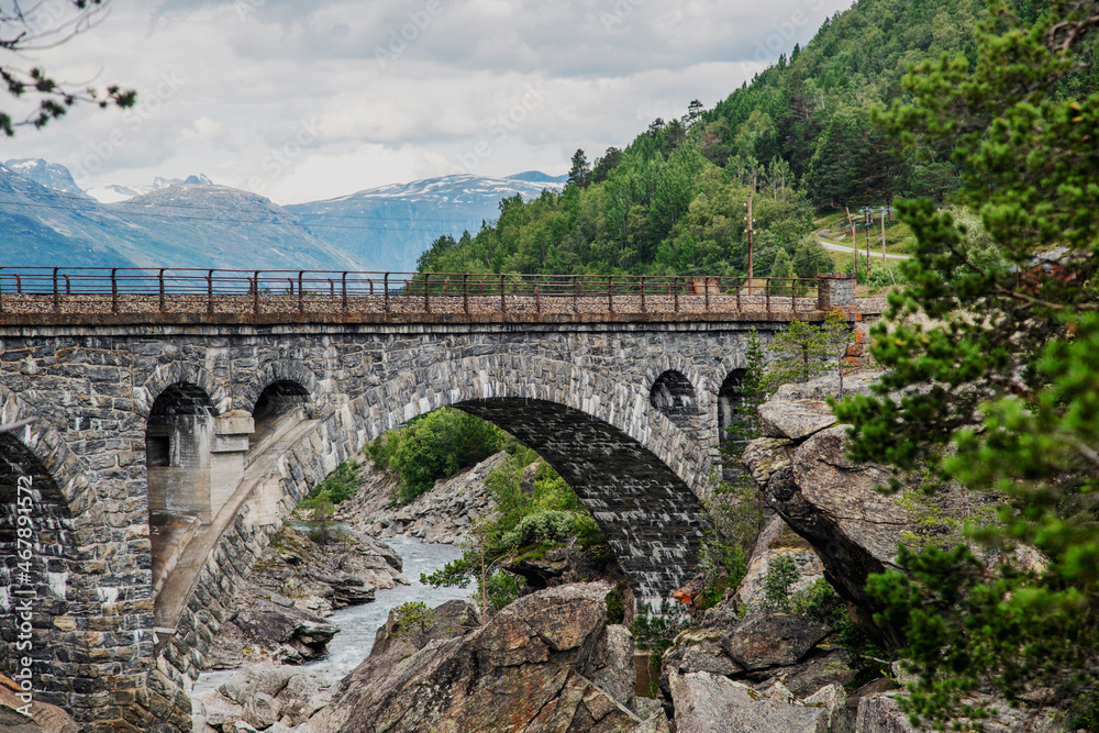 Ancient stone arch bridge in the fjords in Norway. Beautiful Scanlinavian landscape