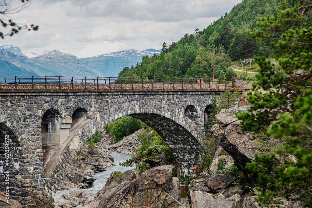Ancient stone arch bridge in the fjords in Norway. Beautiful Scanlinavian landscape Ancient stone arch bridge in the fjords in Norway. Beautiful Scanlinavian landscape