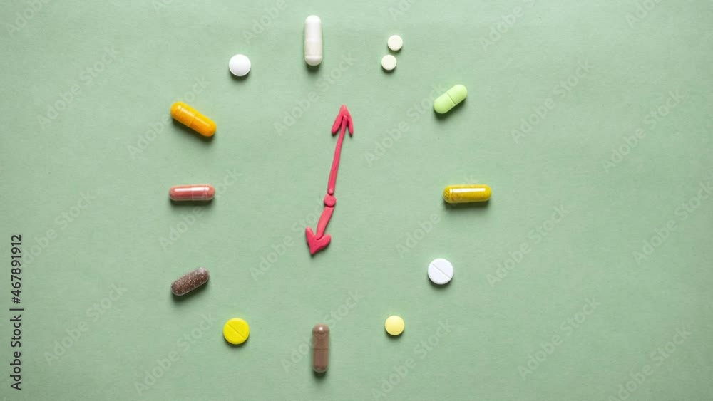 Symbolic clock with plasticine hands and a pill and vitamin dial. Time to drink vitamins. human immunization Symbolic clock with plasticine hands and a pill and vitamin dial. Time to drink vitamins. human immunization