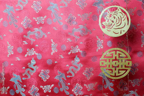 Golden chinese tiger and prosperity symbols on red fabric with chinese ornament birds and dragons. Chinese New Year of the Tiger 2022