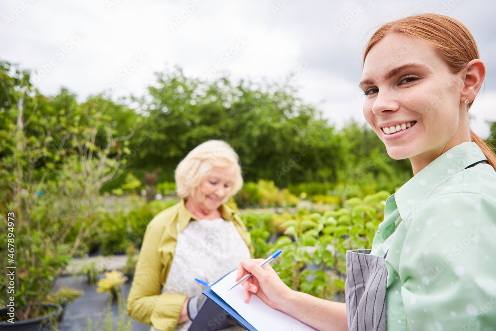 Gärtner Azubi mit Checkliste notiert eine Bestellung Stock Photo