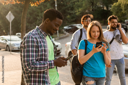 The multi-ethnic students with smartphones are surfing in the internet