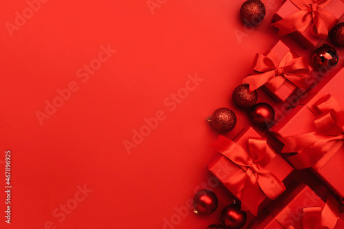 Red gift boxes with ribbons and bows on red background. Merry Christmas and Happy New Year template. Preparation for holidays. Top view. Copy space banner