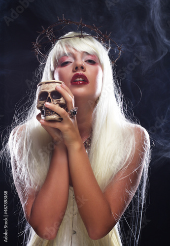 beautiful angelic long hair woman with skull over black background