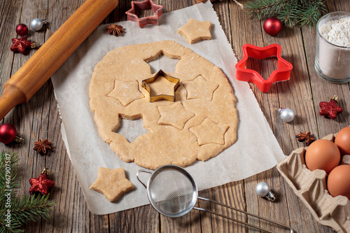 Baking homemade Christmas gingerbread cookies. top view of holiday background with dough spices and fir tree.