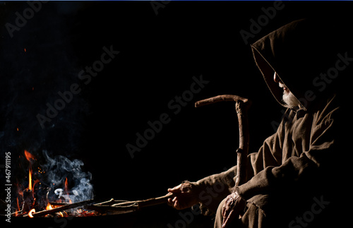 Old druid and celt sit by the fire photo