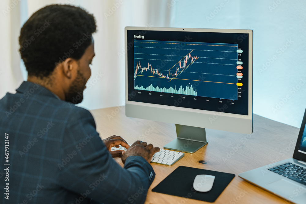Black male trader typing on keyboard Black male trader typing on keyboard