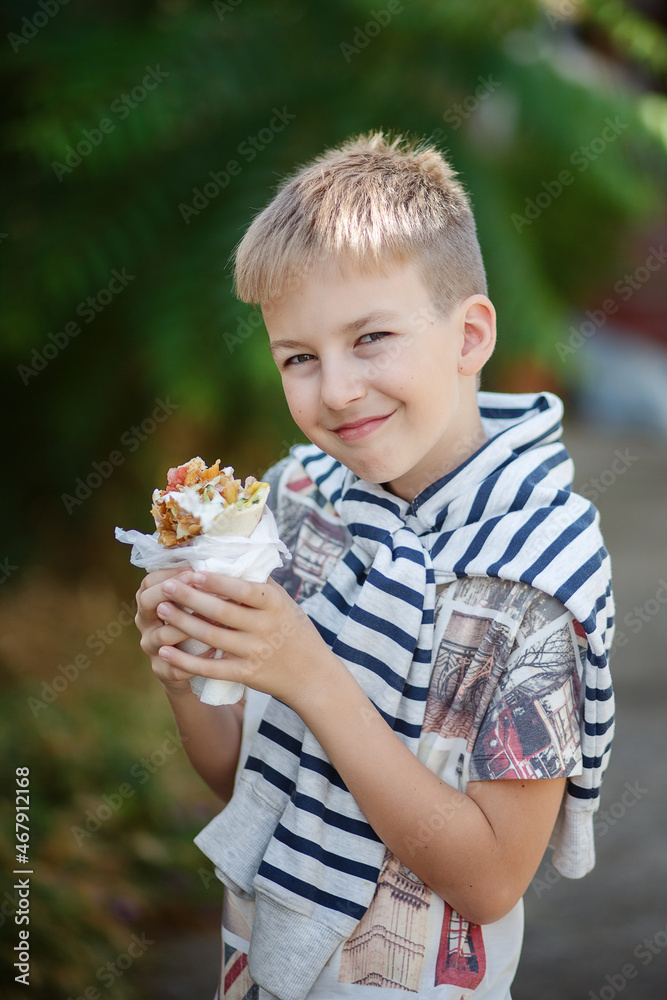 Cute blonde boy eating shrimp roll at fast food restaurant. Unhealthy meal for kids. Junk food. Cute blonde boy eating shrimp roll at fast food restaurant. Unhealthy meal for kids. Junk food.