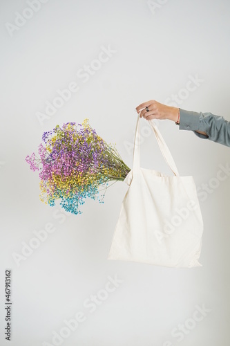 Hands holding shopping bag with flowers