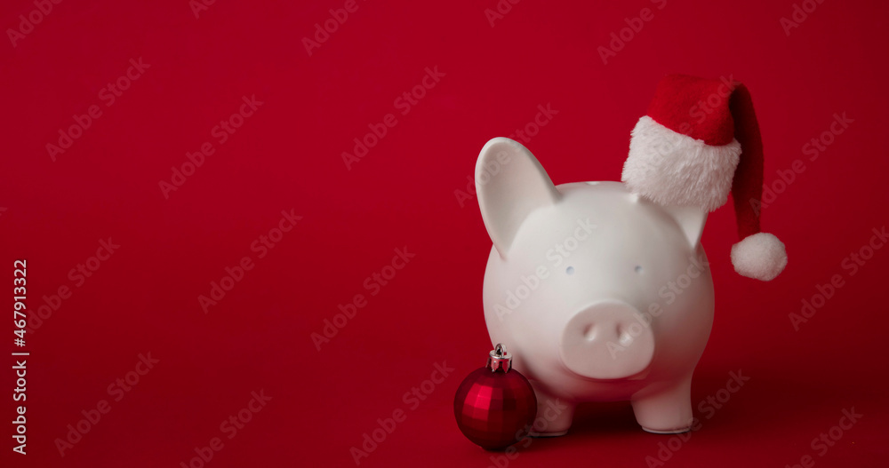 Festive financial savings concept. Piggy bank with Christmas decorations Festive financial savings concept. Piggy bank with Christmas decorations