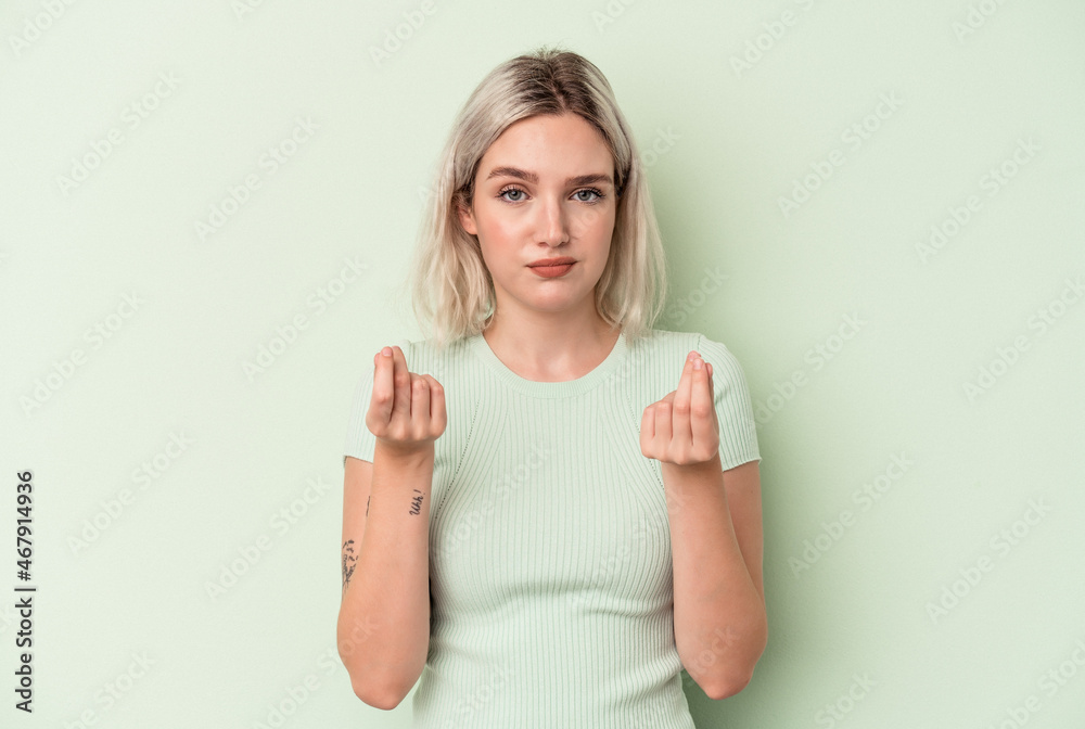 Young caucasian woman isolated on green background showing that she has no money.
