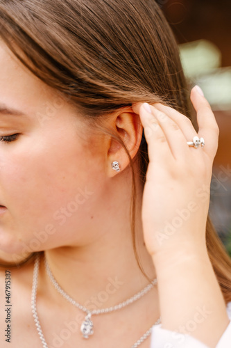 Portrait of a girl wearing silver earrings and a ring with a skull