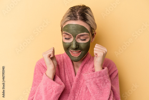 Young caucasian woman wearing face mask isolated on yellow background © Asier