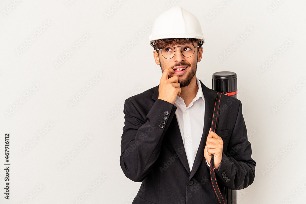 Young mixed race architect man wearing a helmet isolated on grey background relaxed thinking about something looking at a copy space. Young mixed race architect man wearing a helmet isolated on grey background relaxed thinking about something looking at a copy space.