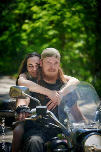 Couple in love riding a motorbike. Handsome guy and young sexy woman travel. Young riders enjoying themselves on trip. Adventure and vacations concept.
