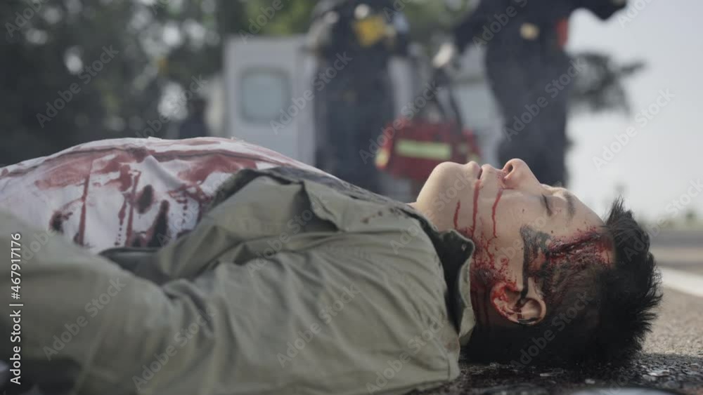 Asian wounded man getting medical supports from paramedics