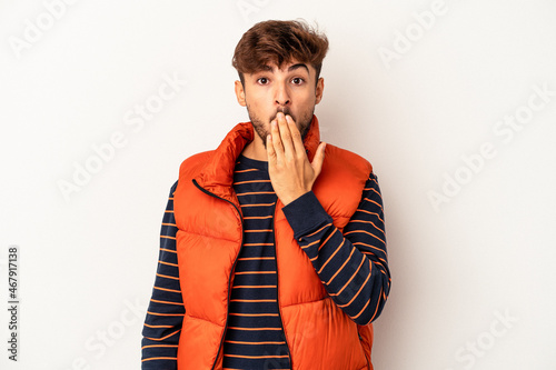 Young mixed race man isolated on grey background shocked, covering mouth with hands, anxious to discover something new. photo