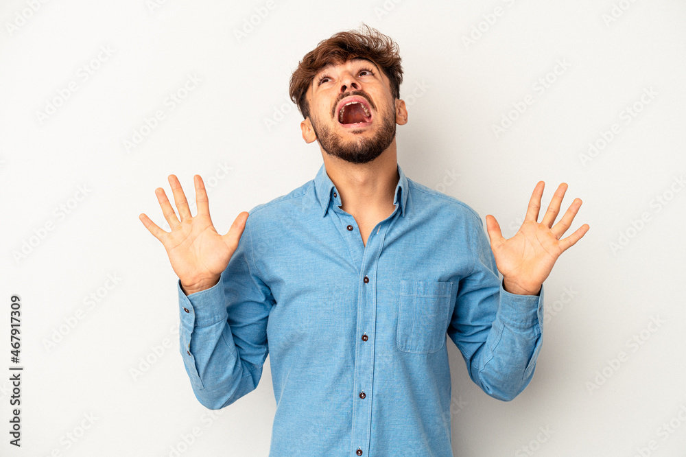 Young mixed race man isolated on grey background screaming to the sky, looking up, frustrated. Young mixed race man isolated on grey background screaming to the sky, looking up, frustrated.