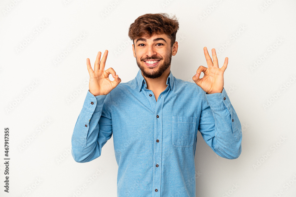 Young mixed race man isolated on grey background cheerful and confident showing ok gesture. Young mixed race man isolated on grey background cheerful and confident showing ok gesture.