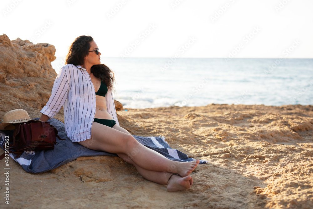 Happy young woman relaxing on the sandy beach. Beautiful woman enjoying a summer day on the beach. Happy young woman relaxing on the sandy beach. Beautiful woman enjoying a summer day on the beach.