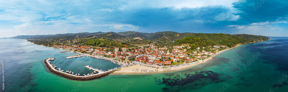 Aerial panorama of Nea Skioni village, marina with boats and yachts , beach, mountain. Halkidiki, Greece