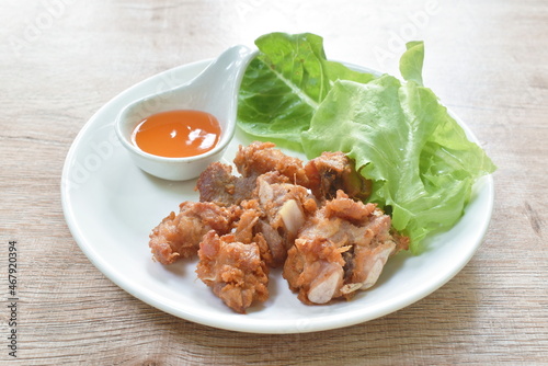 fried fermenting pork bone with garlic dipping chili sauce and fresh vegetable on plate