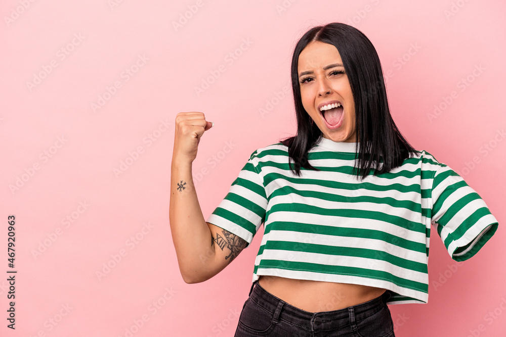 Young caucasian woman with one arm isolated on pink background raising fist after a victory, winner concept. Young caucasian woman with one arm isolated on pink background raising fist after a victory, winner concept.